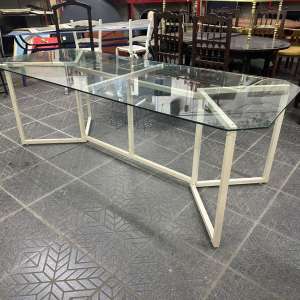 Mesa de comedor en vidrio con base metálica estructural