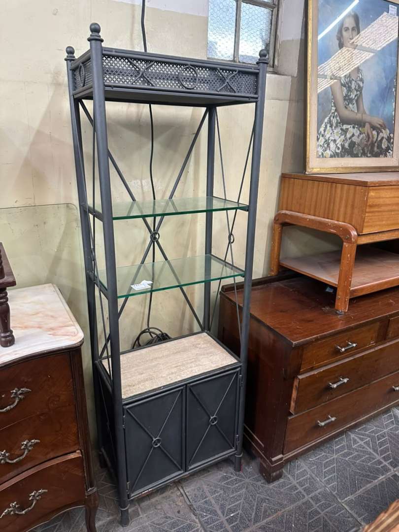 Biblioteca metálica de estilo industrial con estantes de vidrio y base de piedra